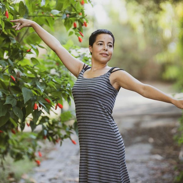 Person stretching gently outdoors with a serene expression.